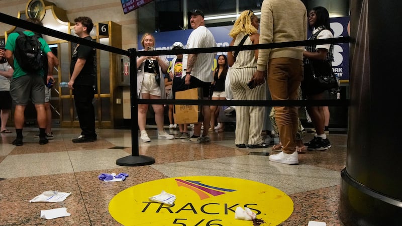 People stand near an area roped off after a stabbing at Penn Station on Sunday, June 7, 2026,...
